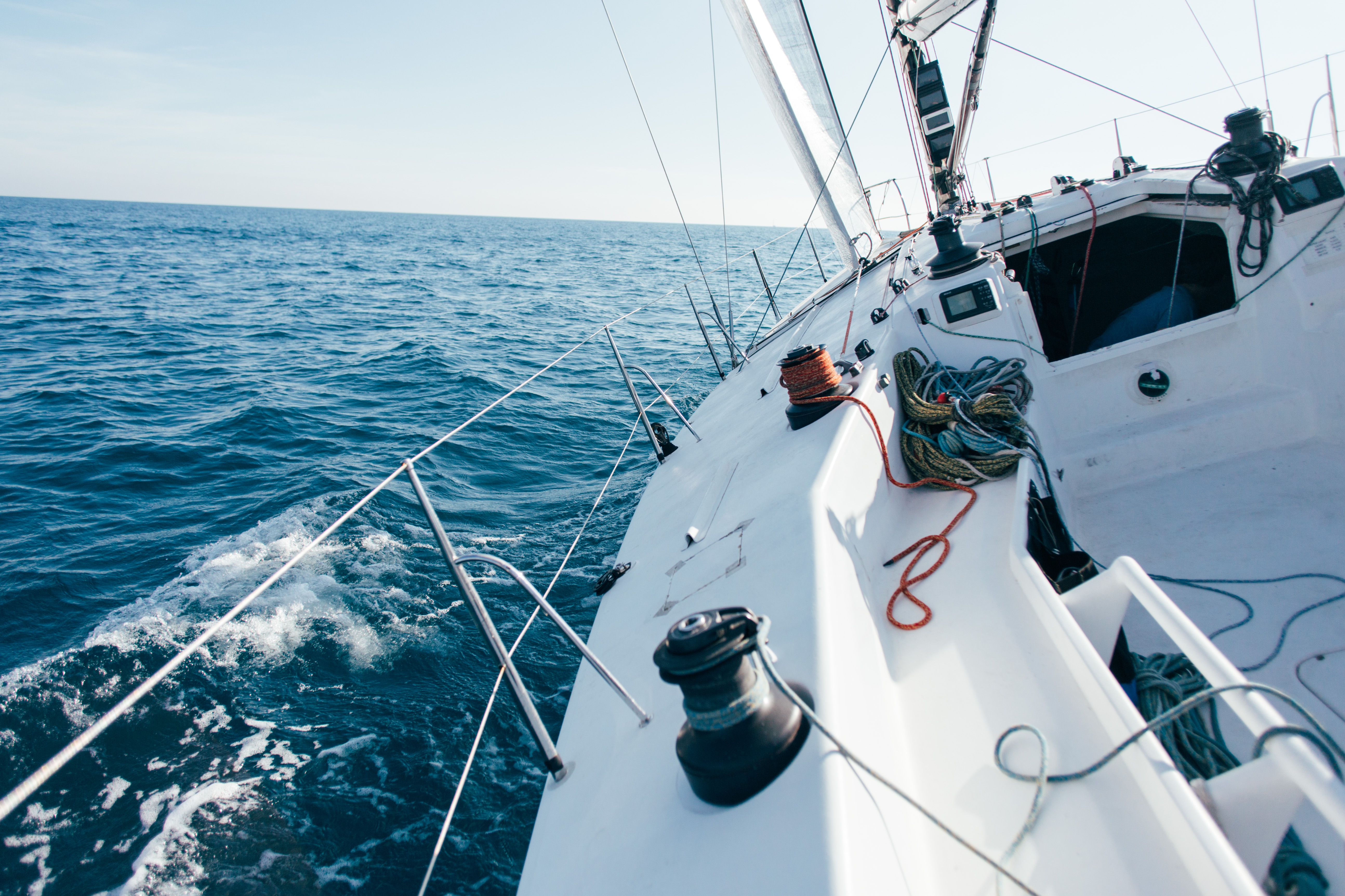 deck professional sailboat racing yacht competition sunny windy summer day moving fast through waves water with spinnaker up